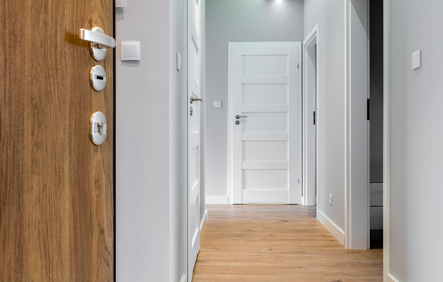 Ein Hausflur mit Zimmertüren aus Holz in verschiedenen Designs
